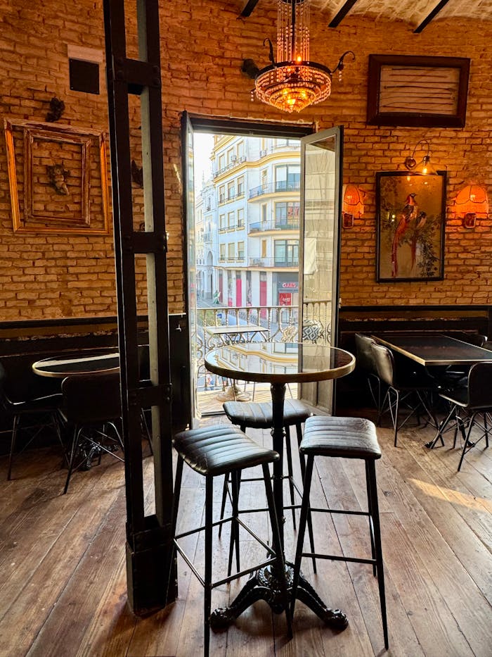 A charming vintage cafe with open doors revealing a bustling city view. Warm ambiance and stylish decor.