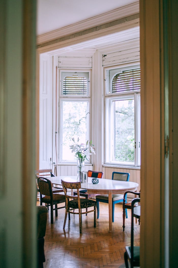 A cozy, vintage-style dining room with large windows and elegant decor, providing a peaceful atmosphere.